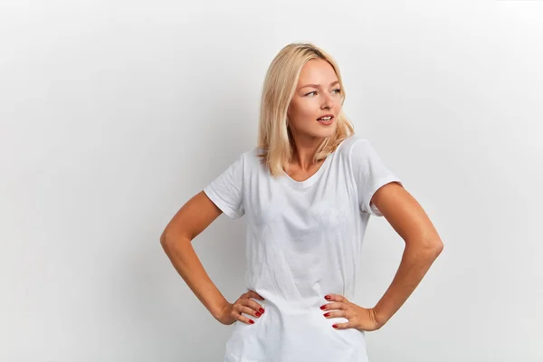 Φοβερό καλό αναζητούν ξανθιά μοντέλο διαφήμιση λευκό T-shirt, κοιτάζοντας στην άκρη — Φωτογραφία Αρχείου