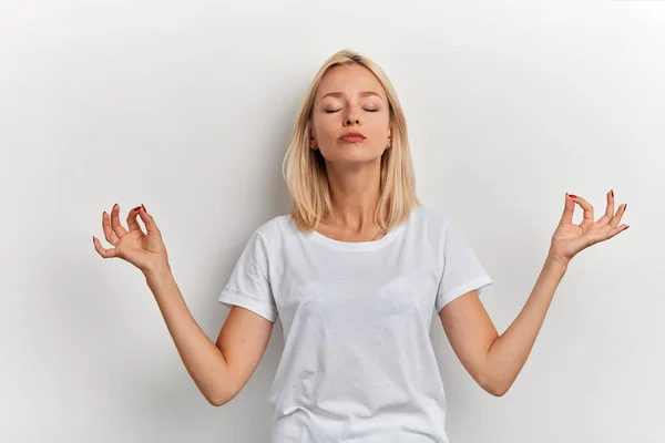 Gut aussehendes tolles Mädchen im weißen T-Shirt, das Yoga genießt — Stockfoto