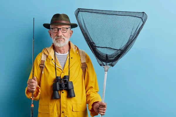 Hombre guapo en ropa casual elegante preparándose para pescar después de la lluvia — Foto de Stock