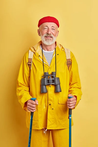 Vecchio turista con binocolo in elegante cappotto si prende cura della salute — Foto Stock