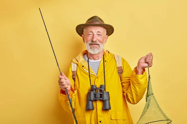 Bonito peixeiro com um pólo de pesca olhando para a câmera — Fotografia de Stock