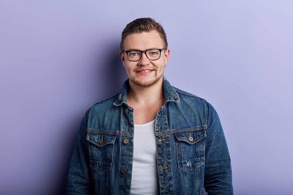 Portrait of handsome stylish young man in glasses posing to the camera