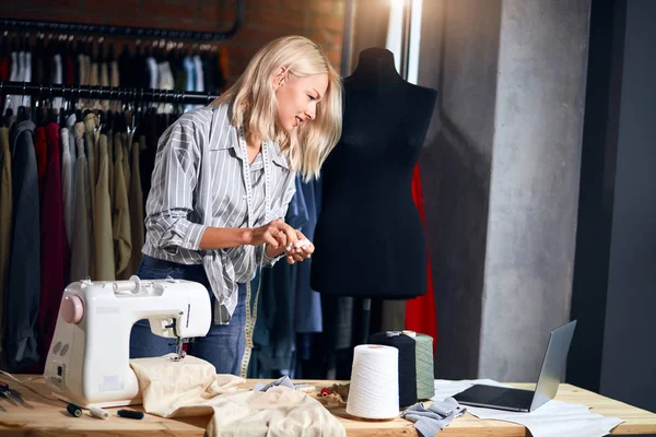 Beautiful designer uses laptop, watches sewing workshop, master class — Stock Photo, Image