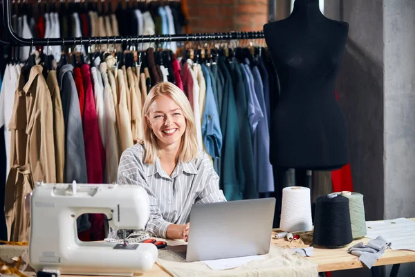 Aantrekkelijke ontwerper zit voor het scherm van de laptop aan tafel — Stockfoto