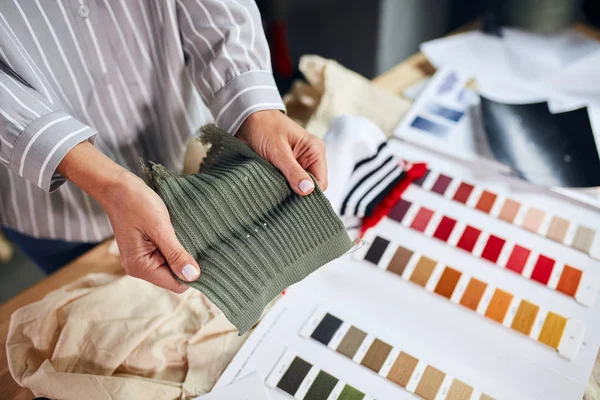 Портной проведение образцов цвета выбирая ткани текстиля на рабочем месте — стоковое фото