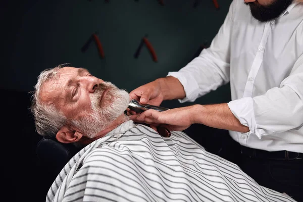 Barbuto vecchio sdraiato sulla sedia con gli occhi chiusi ottenere taglio di capelli — Foto Stock