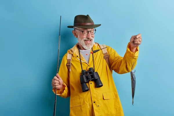 물고기에 기쁘게 표현으로 찾고 쾌활한 노인 — 스톡 사진
