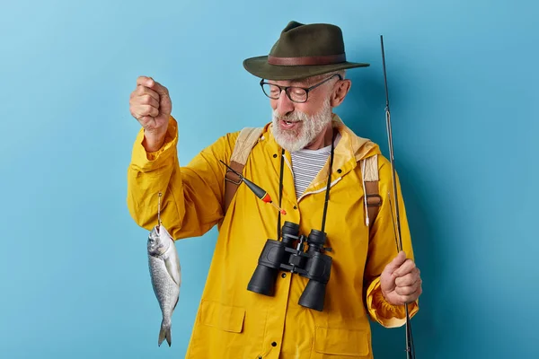 Feliz pescador positivo mirando a sus peces — Foto de Stock