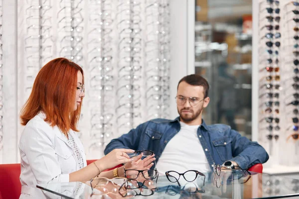 Fundersam tankeväckande man tittar på glas bordet med glasögon — Stockfoto