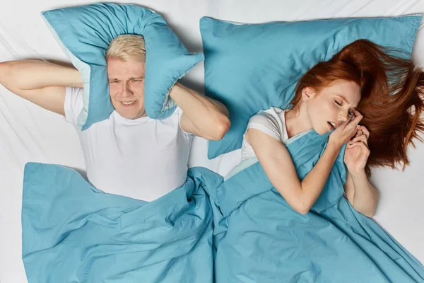 Імбирна жінка хропить уві сні і блондинка страждає на ліжку — стокове фото