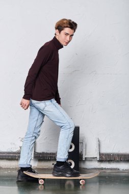 şık kazak serin yakışıklı adam onun kaykay üzerinde duruyor