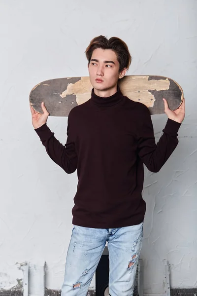 Attractive serious cool man holding his skateboard preparing to ride — Stock Photo, Image