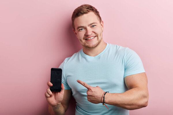 happy brutal man pointing at mobile phone