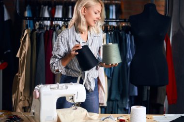 sevimli terzi onları dikmek için seçerek elinde çekme büyük iplik tutan