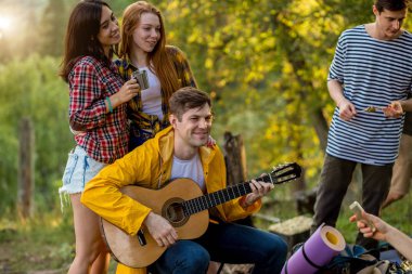 gitar ile çocuğun arkasında dururken sarılma büyüleyici çekici kadın arkadaşlar