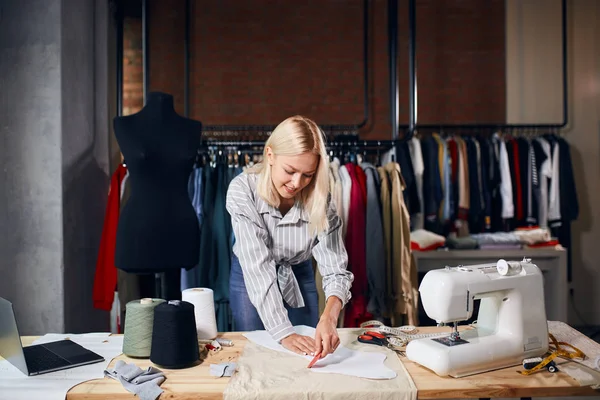 Designer loira alegre que compõe uma roupa de moda — Fotografia de Stock