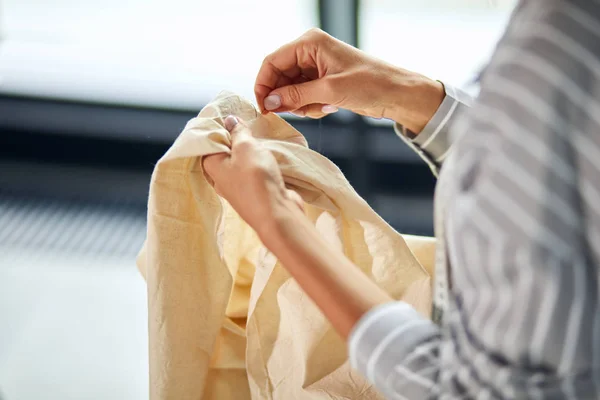 Mujer con camisa a rayas insertando la aguja en tela —  Fotos de Stock