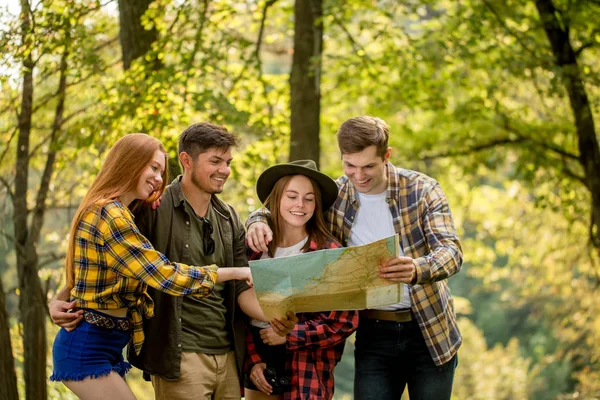 Ridendo escursionisti positivi indicando la mappa — Foto Stock