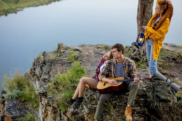 Coppia con chitarra poggiata su una montagna rocciosa — Foto Stock