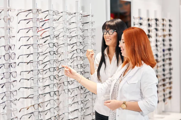 Mulheres positivas gostando de escolher óculos — Fotografia de Stock