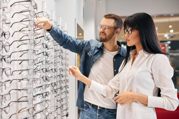 Giovane medico asiatico aiutare un cliente a comprare occhiali — Foto Stock