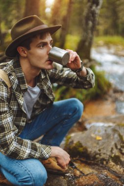 şelaleden su içen genç gezgin