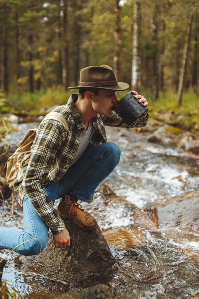 Турист насолоджується випивкою прісної холодної води з річки — стокове фото