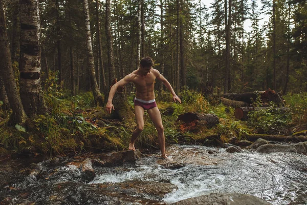 Активний мотивований щасливий чоловік збирається зануритися в річку — стокове фото