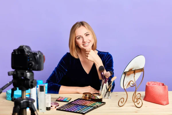 Linda loira feminina maquiagem artista mostrando nova linha de produtos de maquiagem — Fotografia de Stock