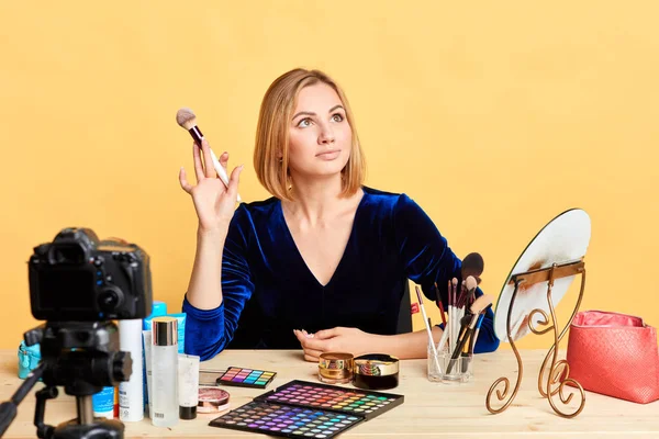 Modelo feminino brilhante posando para maquiagem anúncio segurando escova — Fotografia de Stock