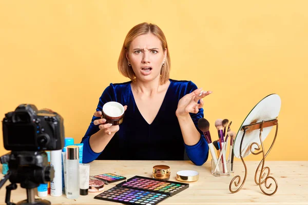 Indignant beaty vlogger showing face cream, dissapointed with the quality — Stock Photo, Image