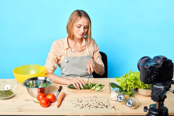 Güzel genç kadın blogger salata için taze çiğ salatalık dilimleme — Stok fotoğraf