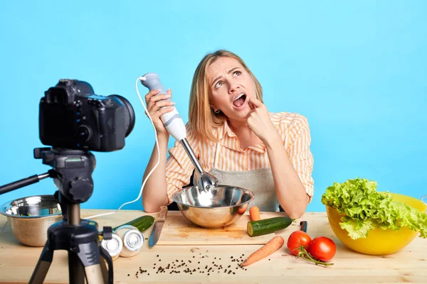 Markýzující unavená ženská blogger, pózující u stolu plného svěží svěží zeleniny — Stock fotografie