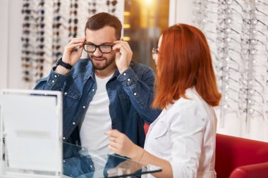 Yakışıklı erkek müşteri klinikte bardak seçerken eğleniyor.