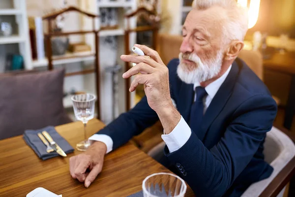 Elegante uomo anziano che fuma calore non bruciato tecnologia del prodotto del tabacco — Foto Stock