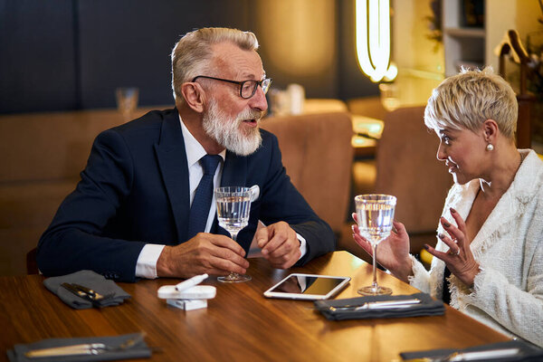 Attractive senior couple sitting in restaurant table and speaking