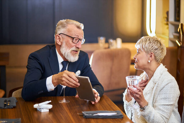 Beautuful senior couple with digital tablet in restaurant