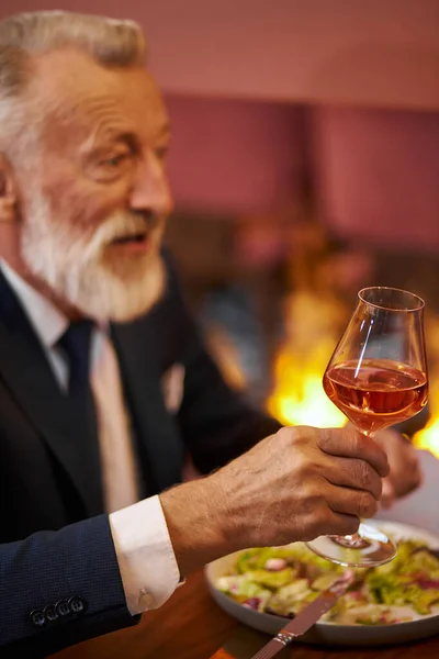 Senior elegante man met glas rode wijn in restaurant — Stockfoto