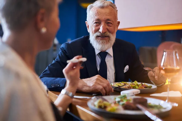 Senior pareja caucásica tener conversación sobre multa comida en restaurante — Foto de Stock