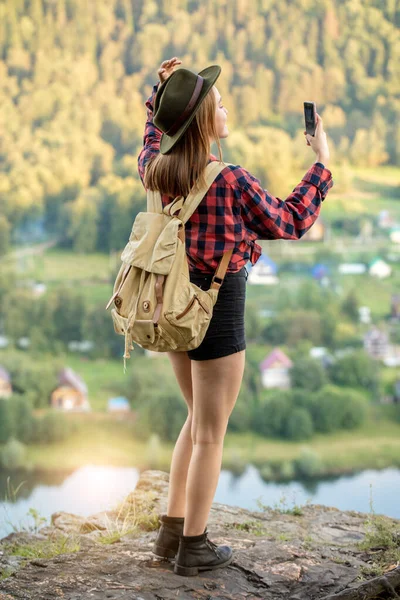 Giovane escursionista donna elegante utilizza smartphone scattare foto di sé — Foto Stock