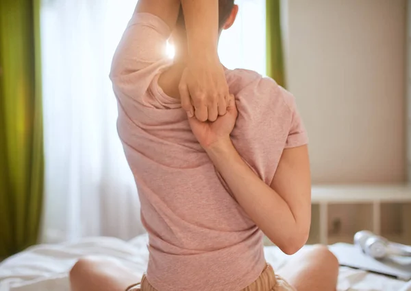 Kortharige vrouw die yoga-oefeningen doet op bed in de lichte kamer. Handen op elkaar. — Stockfoto