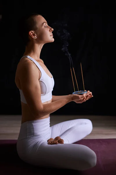 Jonge vrouw ontspannen met roken aromatische stokken. aromatherapie, meditatie — Stockfoto