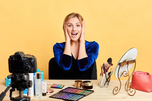 Impressed blogger sits in makeup room with palms near face, expresses happiness — Stock Photo, Image