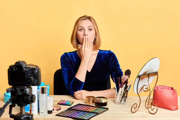 Speechless female beauty expert covers her mouth with hand, shocked expression — Stock Photo, Image