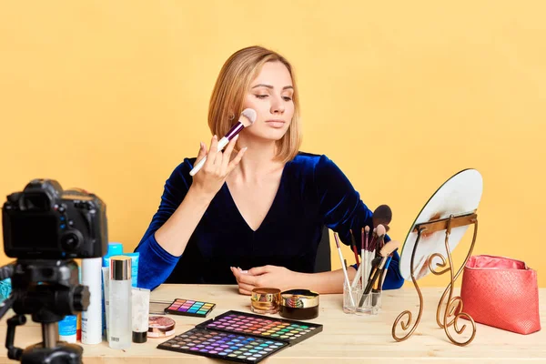 Stylish lifestyle blogger presents makeup products, applies powder with brush — Stock Photo, Image
