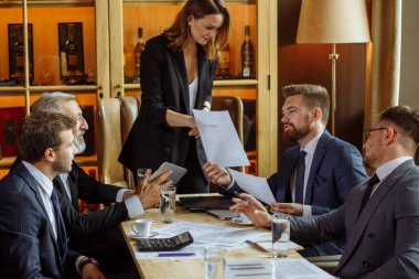 İş ortakları toplantıda belge ve fikirleri tartışıyor