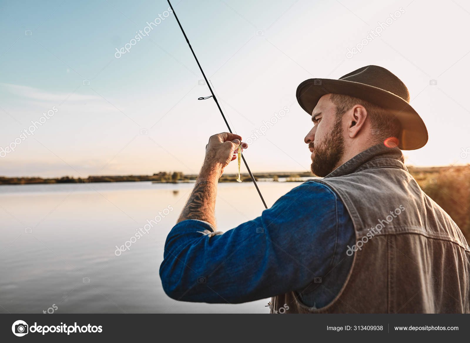 The first joint fishing of adult father and teen son in warm, sunny day.  Stock Photo by ©ufabizphoto 313409938
