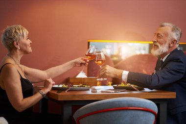 Olgun bir çift restoranda yemek yiyor.
