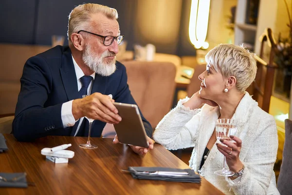 Sköna äldre par med digital surfplatta i restaurang — Stockfoto