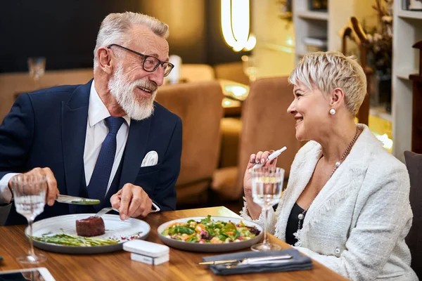 Senior moderna par tar en måltid i restaurang med Iqos, elektronisk cigarett — Stockfoto